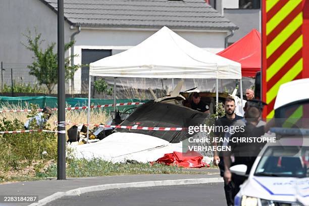 Security personnel look at the wreckage of a Pilatus PC-6 light aircraft after it crashed at Tomblaine, on the outskirts of Nancy, eastern France on...