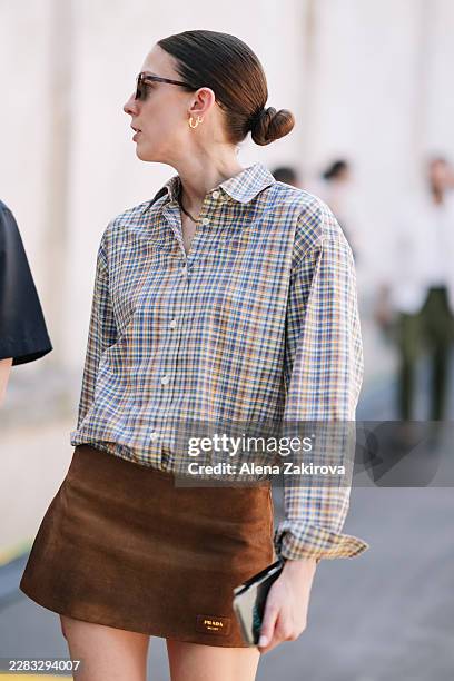 Guest wearing a plaid shirt, a brown suede Prada mini skirt is seen outside Prada show during the Milan Fashion Week - Menswear Spring/Summer 2027 on...