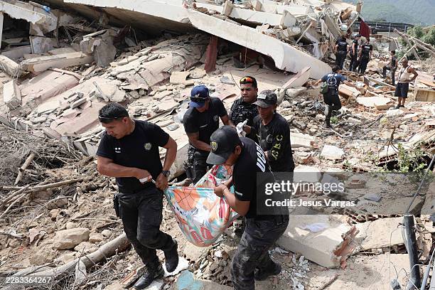 Police members tend a victim amid debris of demolished buildings as rescue efforts continue after a magnitude 7.2 earthquake struck Venezuela and...