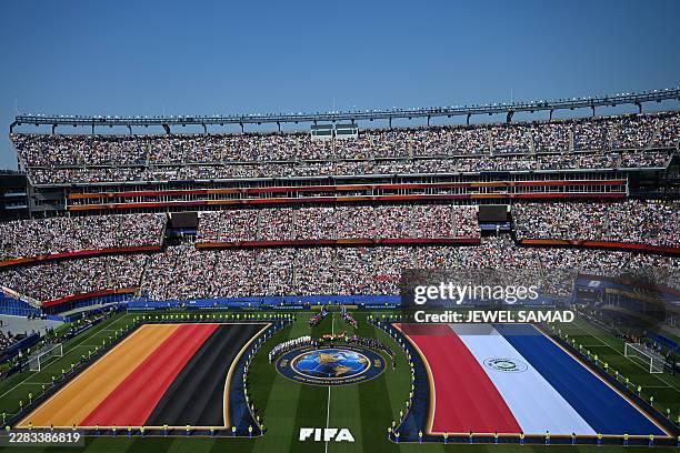 Germany and Paraguay players stand on the pitch for the national anthems ahead the 2026 World Cup round of 32 football match between Germany and...