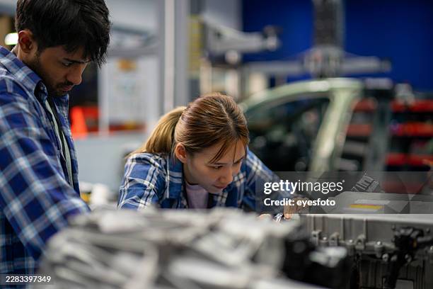 two engineers examining electric vehicle battery module in workshop - learning module stock pictures, royalty-free photos & images