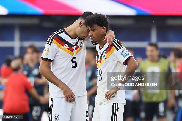 Germany's defender Aleksandar Pavlovic and defender Nathaniel Brown react after losing the penalty shootout of the 2026 World Cup round of 32...
