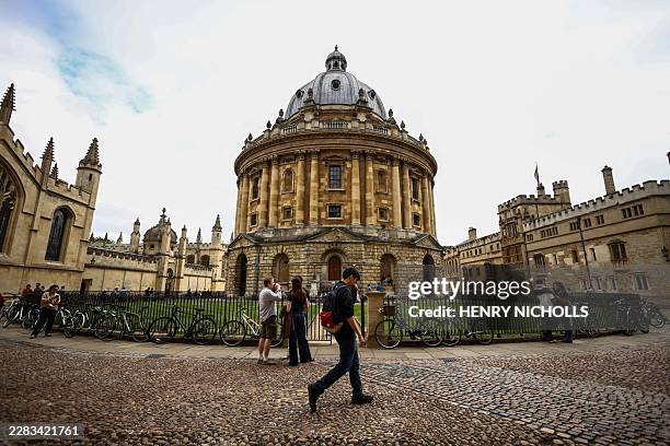 This photo taken on June 17, 2026 shows people walking past the Radcliffe Camera building at Oxford University in Oxford, central England. With its...
