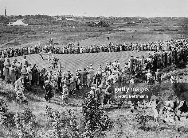 Spectators look on as Alf Padgham and Henry Cotton of the England team playing Ed Dudley and Byron Nelson of the United States team during the...