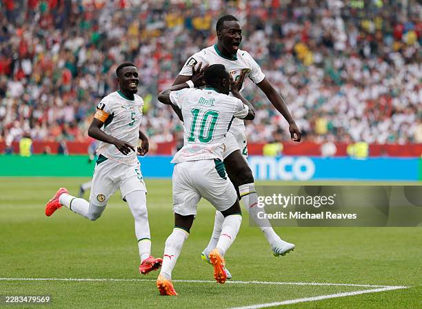 Pape Gueye of Senegal celebrates with teammates Sadio Mane and Idrissa Gana Gueye after scoring his team's third goal during the FIFA World Cup 2026...