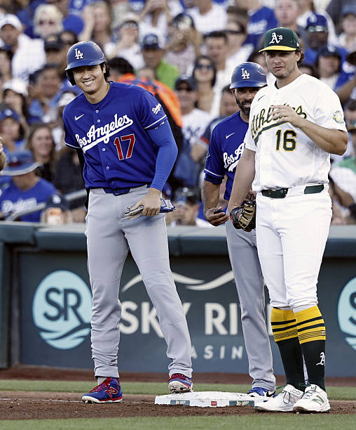Los Angeles Dodgers designated hitter Shohei Ohtani reacts alongside Athletics first baseman Nick Kurtz after hitting a single in the fourth inning...