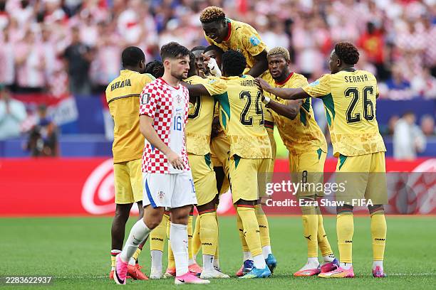 Derrick Luckassen of Ghana celebrates with teammates after scoring his team's first goal while Martin Baturina of Croatia shows dejection during the...