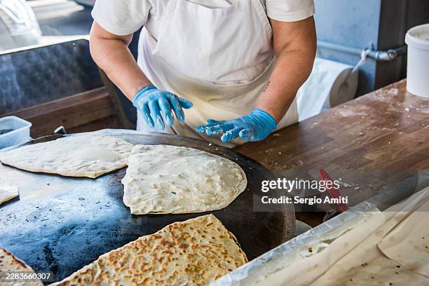 cook pressing flatbread on griddle market bow - commercial griddle stock pictures, royalty-free photos & images