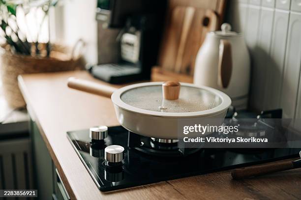 cooking with ceramic frying pan top view, top view of cooking process using cream ceramic frying pan on induction stove for premium cookware and recipe concept photography. - deep clean kitchen stock pictures, royalty-free photos & images