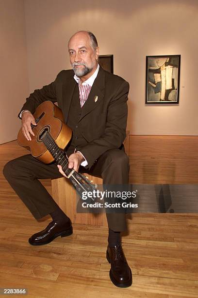 Mick Fleetwood holding Stuart Sutcliffe's first guitar at a press conference to unveil the artwork and memoriblia of Mr. Sutcliffe, the "5th Beatle",...