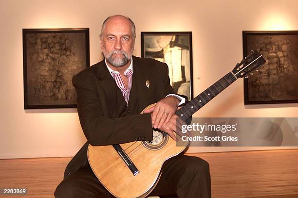 Mick Fleetwood holding Stuart Sutcliffe's first guitar at a press conference to unveil the artwork and memoriblia of Mr. Sutcliffe, the "5th Beatle",...