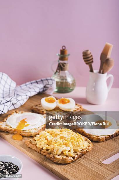 scrambled egg, poached egg, fried egg, boiled egg on toast on a board vertical view - hard boiled candy stock pictures, royalty-free photos & images