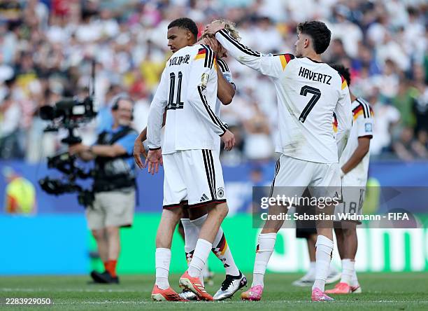 Nick Woltemade of Germany is consoled by teammates Malick Thiaw and Kai Havertz after missing his team's fourth penalty in the shootout during the...