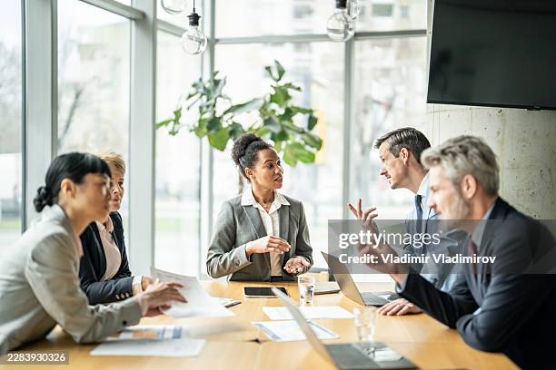 geschäftsleute, die sich im modernen büro treffen - risikomanagement stock-fotos und bilder