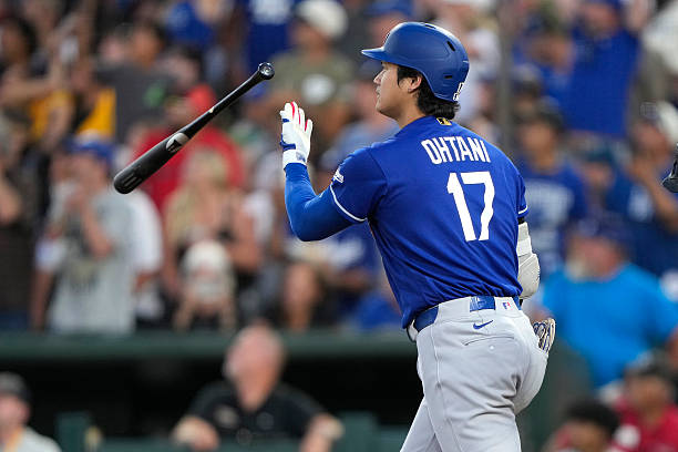 Shohei Ohtani of the Los Angeles Dodgers tosses his bat after hitting a three-run home run against the Athletics in the top of the six inning of a...
