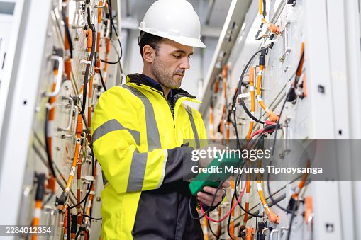 Electrical Engineer Performing High-Voltage Testing on Battery Energy Storage System Using ç Multimeter Electrical Engineer Performing High-Voltage Testing on Battery Energy Storage System Using ç Multimeter
