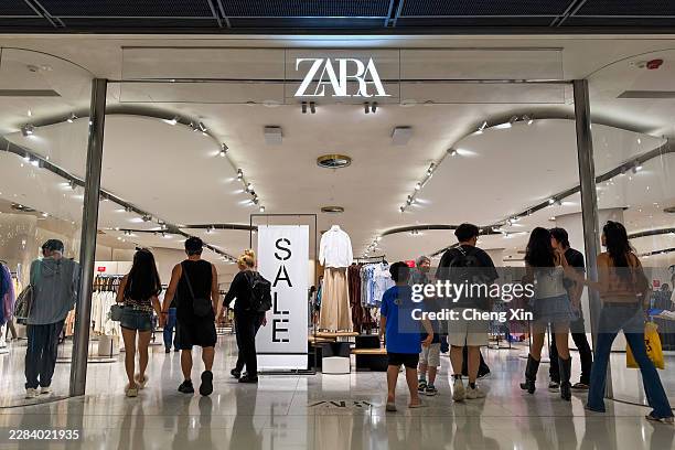 Shoppers enter a Zara store displaying summer sale promotions on June 30 in Hong Kong, China. Retailers across Hong Kong continue to offer seasonal...