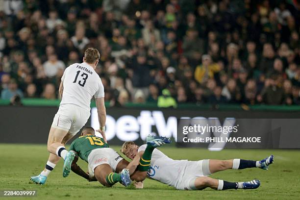 South Africa's fullback Damian Willemse tackles England's centre Tommy Freeman during the rugby Nations Championship match between South Africa and...