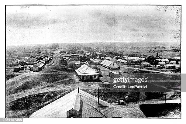 a high-angle panoramic view capturing a worker settlement spreading across the landscape around a mining site - mining africa stock illustrations