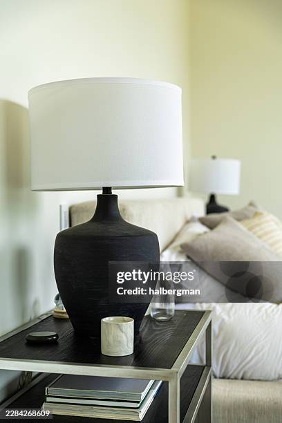 black ceramic table lamp with white shade on bedside table - black marble table stock pictures, royalty-free photos & images