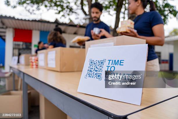 spenden-qr-code-schild auf einem tisch bei einer wohltätigkeitsveranstaltung - fundraising stock-fotos und bilder
