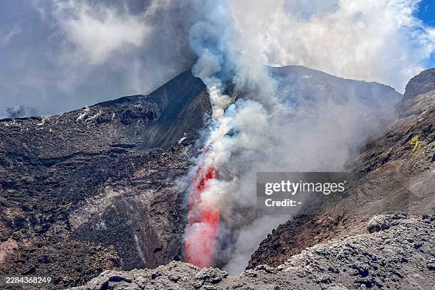 Photograph taken on July 6, 2026 shows lava flowing and smoke rising from the crater during an eruption of the Mount Etna volcano in Sicily.