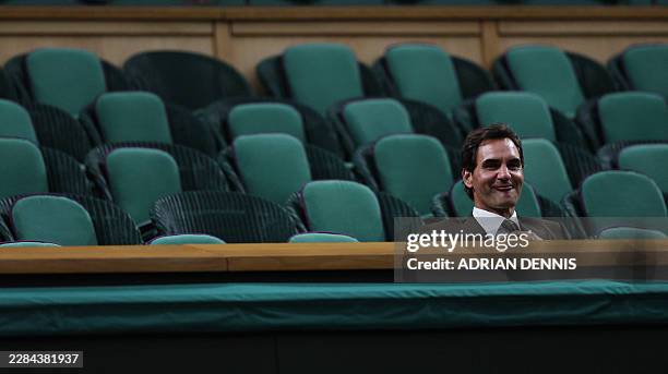 Swiss former tennis player Roger Federer smiles sitting in the Centre Court's Royal Box on the eighth day of the 2026 Wimbledon Championships at The...