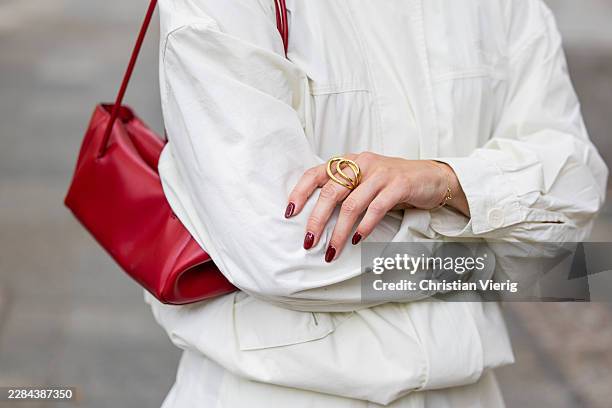 Tina Haase wears Baum & Pferdgarten cream Windbreaker jacket & midi skirt, red baguette bag Zara, red nail polish, golden ring during the Berlin...