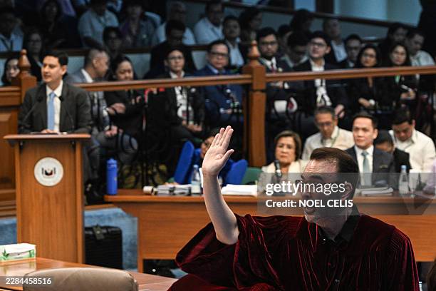 Philippine Senator Alan Peter Cayetano raises his hands to give a statement during the impeachment trial of Philippine Vice President Sara Duterte at...