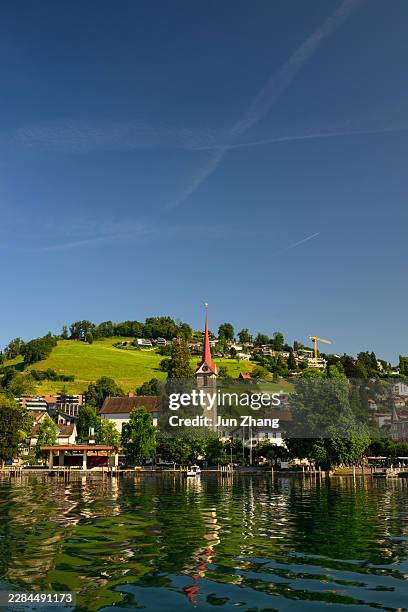 tranquil scene of small town weggis on lake lucern, switzerland, under blue sky, in early morning sunlight - lake lucerne stock pictures, royalty-free photos & images