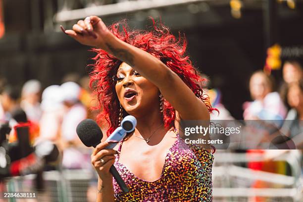 drag performer entertaining the crowd with microphone during pride in london parade, england, uk - singer songwriter stock pictures, royalty-free photos & images
