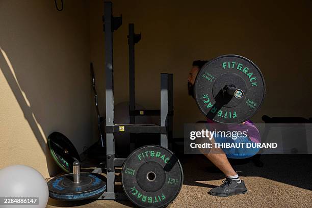 Man performs a barbell squat during a personal training session in Malemort-du-Comtat, Vaucluse, Provence Alpes Cote d Azur, France, July 6, 2026....