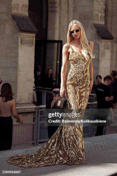 Maren Tschinkel wears long golden maxi dress, black Schiaparelli bag and sunglasses outside Rahul Mishra during Day One of Paris Fashion Week - Haute...