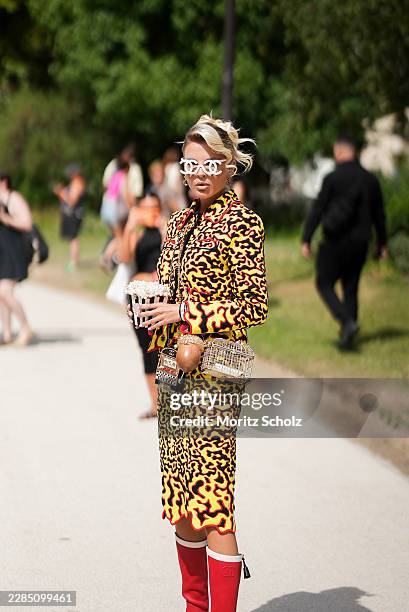 Guest is seen wearing a yellow black and red printed tailored jacket from Chanel; a matching yellow black and red printed pencil skirt from Chanel;...