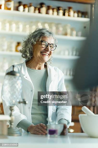 fröhlicher reifer chemiker, der im labor arbeitet. - homöopathie stock-fotos und bilder