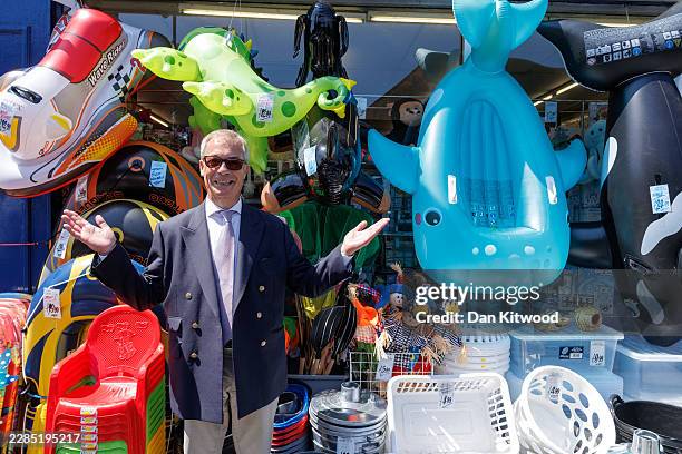 Reform UK leader Nigel Farage stops outside a bucket and spade shop for a photograph while speaking to members of the public on the High Street on...