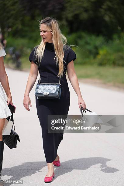 Guest wears long straight blonde hair, a black puffy short sleeves long dress, a black shiny leather Boy crossbody bag from Chanel, red pink...
