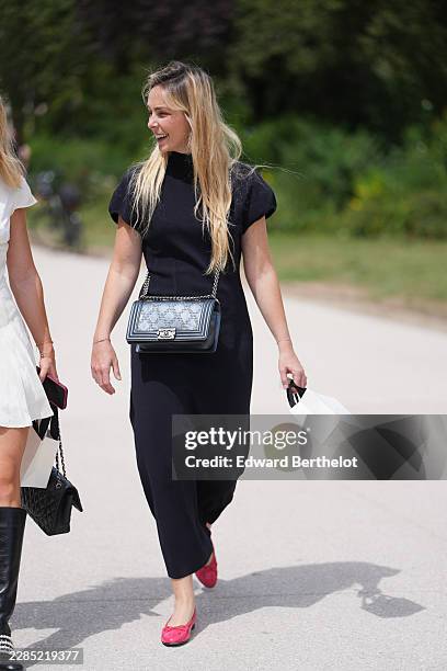 Guest wears long straight blonde hair, a black puffy short sleeves long dress, a black shiny leather Boy crossbody bag from Chanel, red pink...