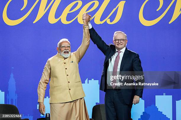 Indian Prime Minister Narendra Modi and Australian Prime Minister Anthony Albanese raise their joined hands on stage inside Marvel Stadium on July...
