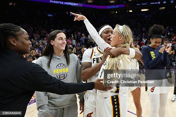 Sophie Cunningham of the Indiana Fever points to the fans as she celebrates with Caitlin Clark and Monique Billings following the WNBA game against...