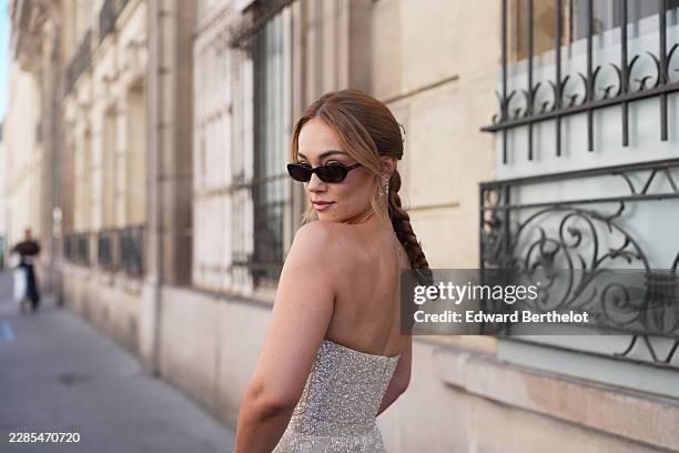 Merve Gorgoz wears medium-length updo light brown braided hair with silver and diamonds moon and stars shape hair clips, black sunglasses, a...
