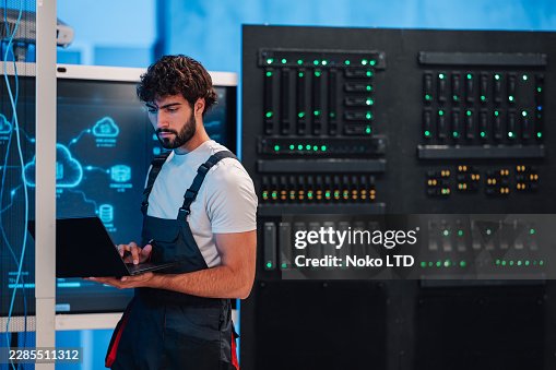It technician man using laptop computer for network administration, cloud computing, and cybersecurity in server room It technician man using laptop computer for network administration, cloud computing, and cybersecurity in server room