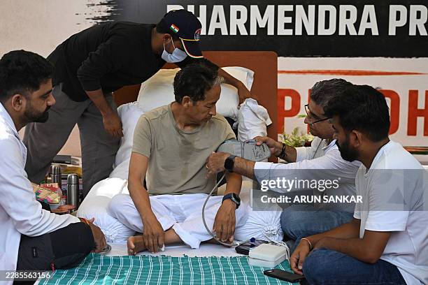 Cockroach Janta Party founder Abhijeet Dipke watches as doctors check activist Sonam Wangchuk's vital signs during his hunger strike in New Delhi on...