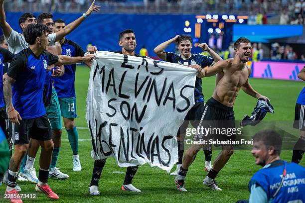 Lisandro Martinez, Cristian Romero, Giovani Lo Celso with a banner during the FIFA World Cup 2026 Semi Final match between England and Argentina at...