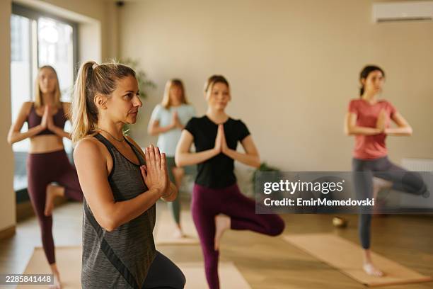 women practicing tree pose during yoga class - tree pose stock pictures, royalty-free photos & images