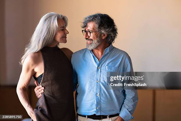 happy mature couple embracing and smiling indoors - pair stock pictures, royalty-free photos & images