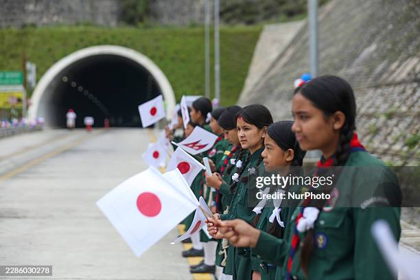 Nepali students wave the flags of Nepal and Japan during a promotional and awareness event organized at the Nagdhunga-Naubise transport tunnel, built...