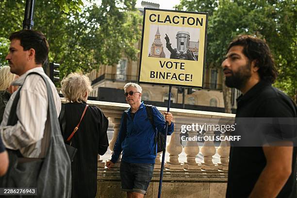 Man holds a placard reading "Clacton Vote Binface", in reference to the snap August 13 Clacton by-election which pits Reform UK leader Nigel Farage...