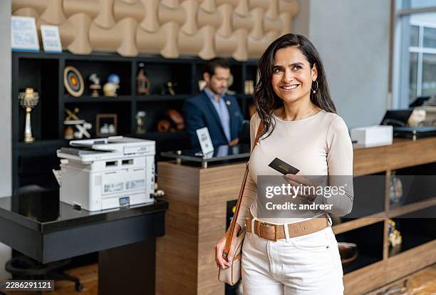 traveler at a hotel reception holding a keycard - loyalty card stock pictures, royalty-free photos & images
