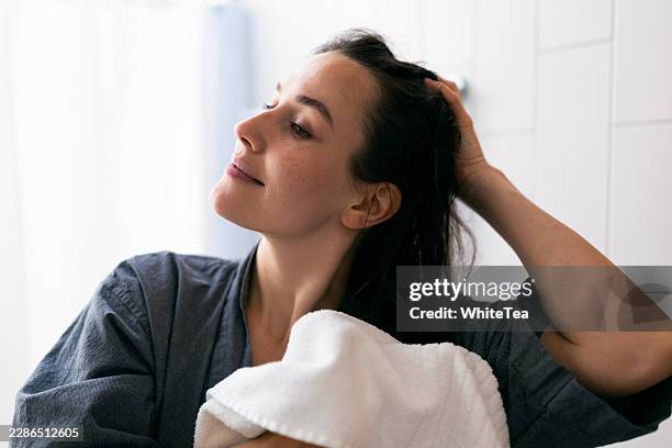 femme qui sèche ses cheveux avec une serviette après la douche - main dans les cheveux photos et images de collection